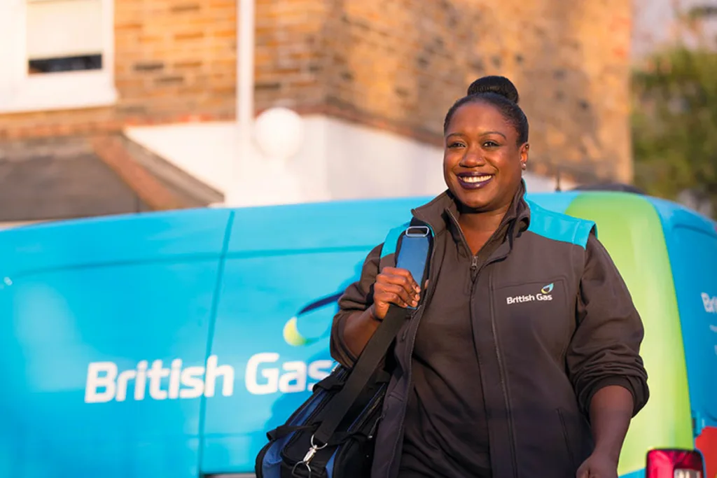 Female British Gas engineer walking in front of a British Gas van
